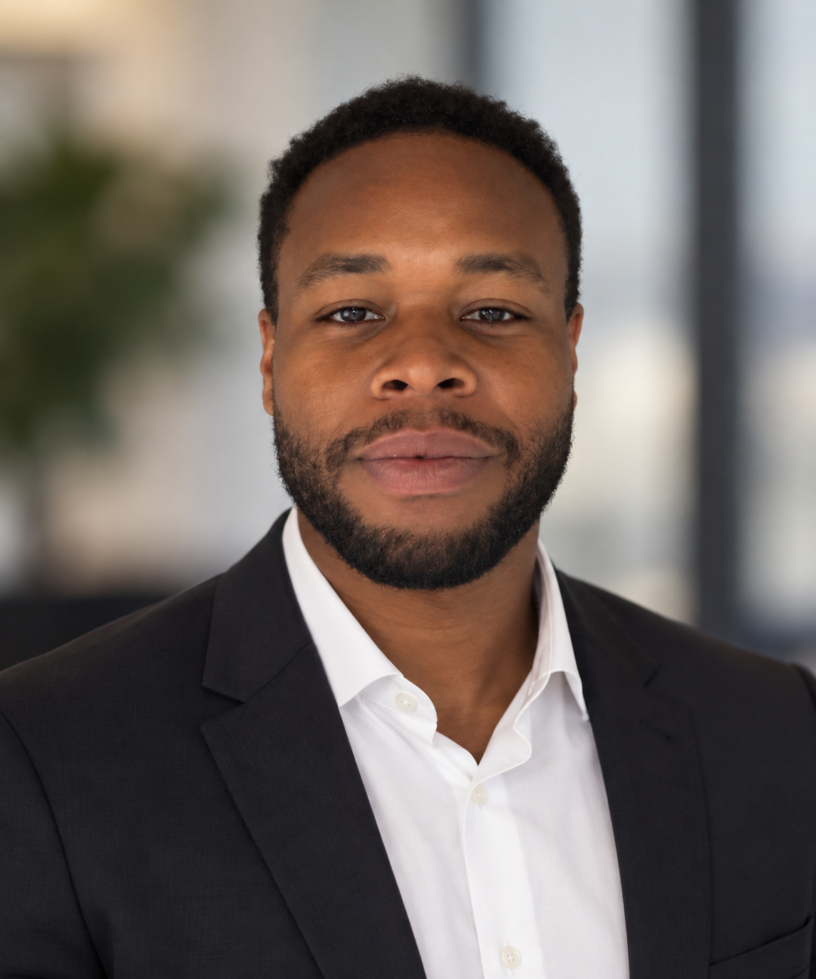 Ausar McGruder smiling in a dark suit and white shirt